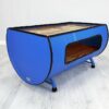 Seitenansicht des Upcycling Retro Ölfass Couchtischs "Nele" in Blau mit Holz Sitzfläche – Nachhaltiges Möbelstück