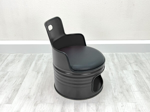 Ölfass Sessel , schwarzem Sitzpolster und Stauraum unter der Sitzfläche vor weißem Hintergrund