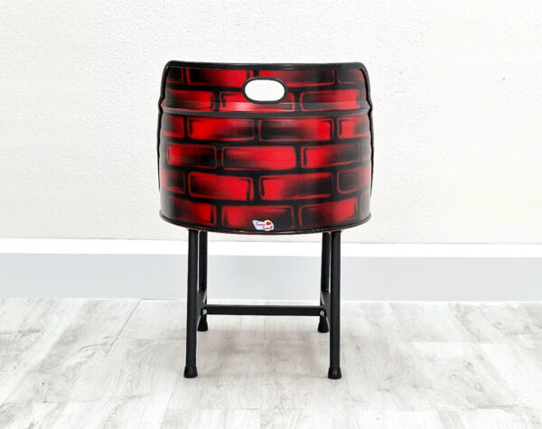 Ölfass Esszimmer Stuhl in Rot mit aufgesprayten Backsteinen auf der Rückseite, mit schwarzem Sitzpolster und schwarzen Metallbeinen auf weißem Holzboden vor weißem Hintergrund