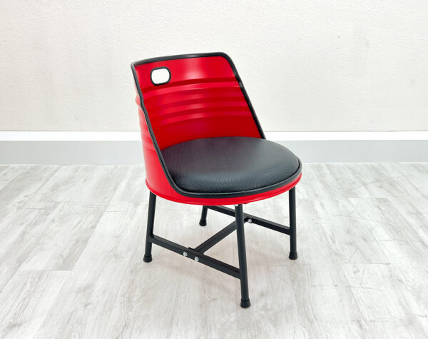 Upgecycelter Ölfass Esszimmer Stuhl in Rot mit schwarzem Sitzpolster, schwarzen Metallbeinen und schwarzem Kantenschutz auf weißem Holzboden vor weißem Hintergrund