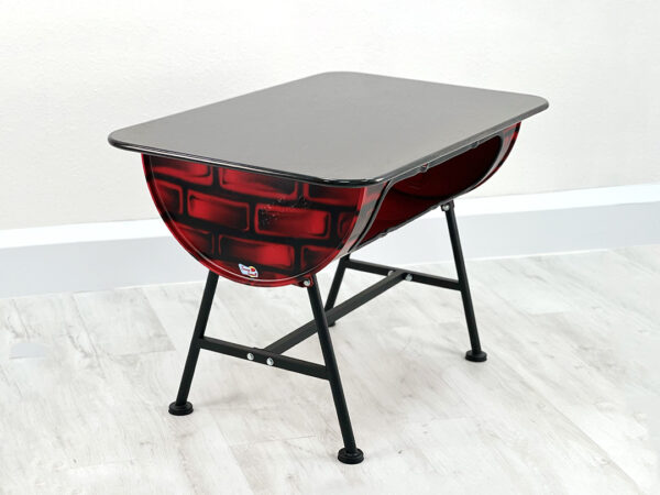 Ölfass Esszimmer Tisch in Rot mit aufgesprayten Backsteinen, mit schwarzem Sitzpolster und schwarzen Metallbeinen auf weißem Holzboden vor weißem Hintergrund