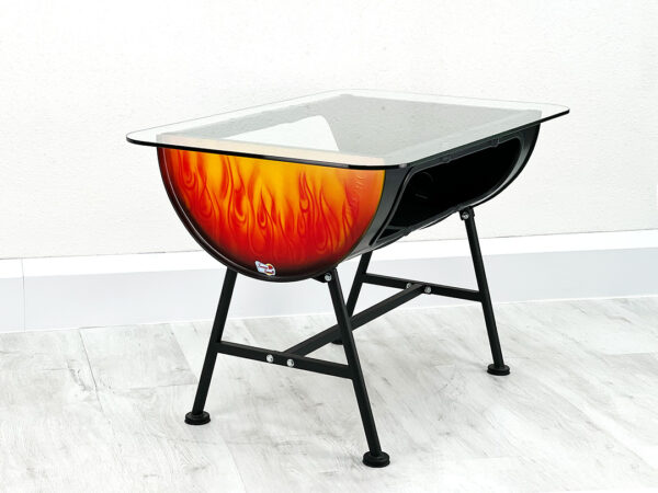 Ölfass Esstisch Mick mit Glastischplatte im Flammendesign auf schwarzen Beinen vor weißer Wand auf weißem Holzboden