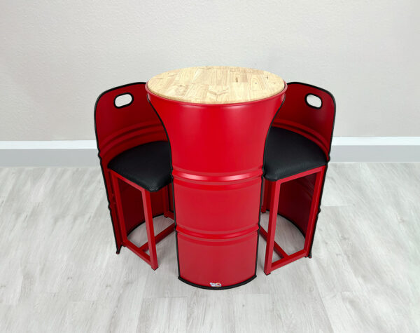Roter Stehtisch aus Ölfass in den seitlich 2 rote Barhocker mit integriertem schwarzen Polster geschoben werden können, mit heller Holztischplatte auf weißem Holzboden vor weißer Wand