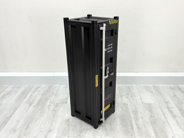 Schwarzer geschlossener Hochschrank in Überseecontainer Optik auf weißem Holzboden vor weißer Wand
