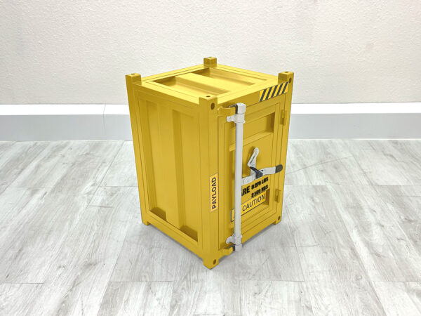 Kleiner gelber Containerschrank aus Metall mit geschlossener Tür auf weißem Holzboden vor weißer Wand