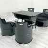 Ölfass Sitzgruppe in Grau mit schwarzen Sitzpolstern, bestehend aus vier Sesseln und einem Tisch mit Granitplatte auf weißem Holzboden.