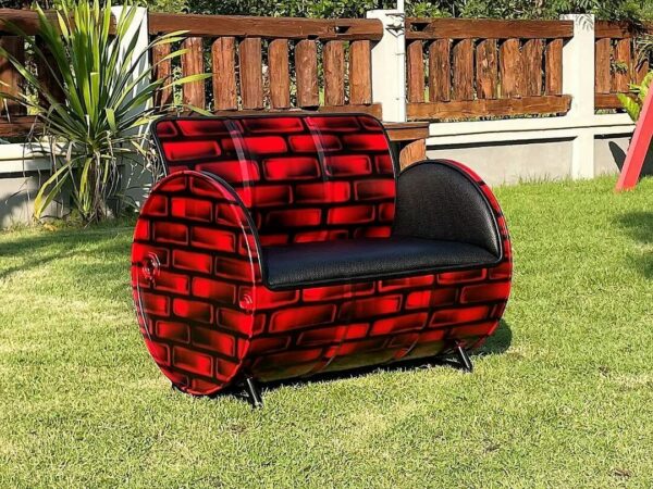 Seitenansicht des eleganten Ölfass Upcycling Sofas "Carla" in einer beeindruckenden Backstein Optik in Schwarz-Rot, veredelt mit hochwertigem Kunstleder Bezug - Tonnen Tumult